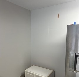 Bare garage wall marked for cabinet layout
