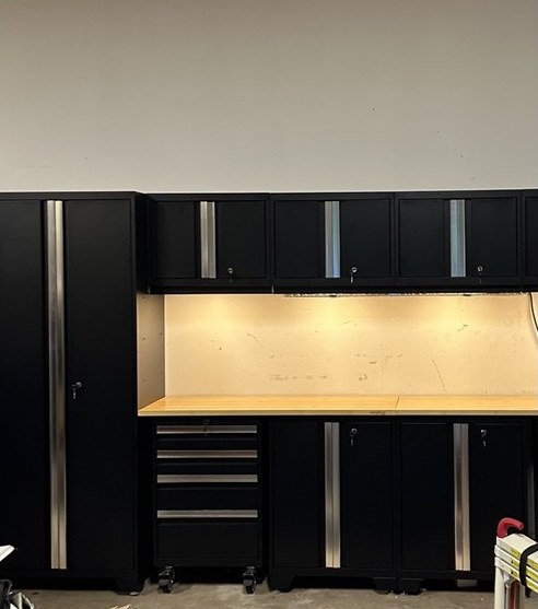 Black NewAge Bold garage cabinets with lockers, wall cabinets and a lit workbench