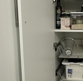 Open pantry cabinet showing shelves and pull-outs